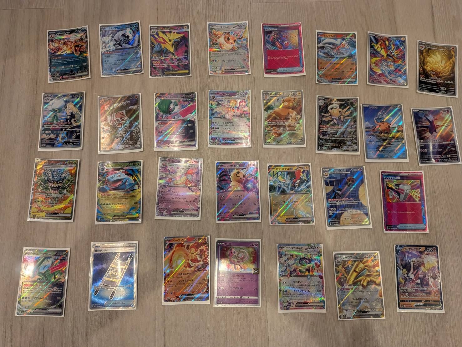スリーブに入れたポケモンカードを床に並べて撮影した写真
